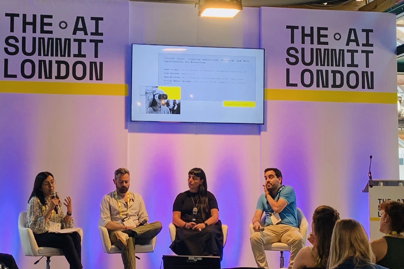 Dr Swati Virmani speaking into a microphone on the Industries Stage panel at The AI Summit London, seated with three other panellists. The screen behind them shows the session title 'ChatGPT Focus: Creating Educational Standards and Work Opportunities for Minorities'.